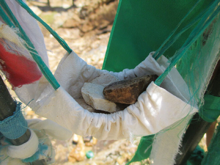 âRocks-in-a-cradleâ are votive offerings attached to the metal grille surrounding Abdal Musaâs rock-throne