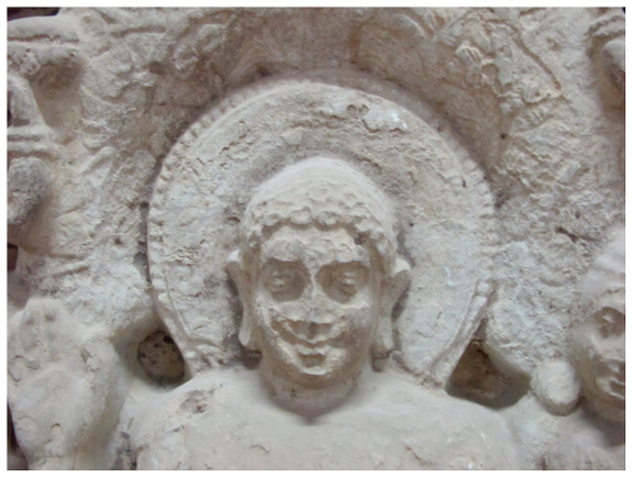 It shows the head of the Buddha with a halo embroidered with a decorative border.