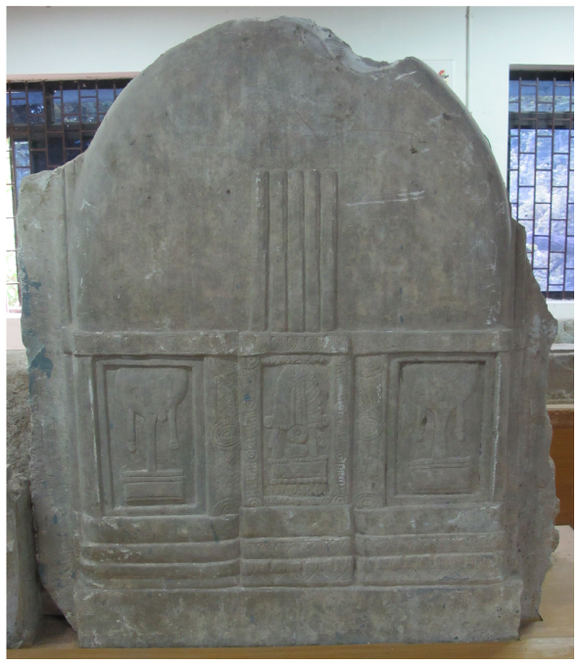 It depicts a plain miniature stūpa. The base section of the stūpa depicts a tree, a throne with a flaming pillar, and a tree in three registers.