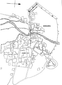 A map of Singara. It shows the modern town at the bottom of the map leading to the old town at the top, with Roman walls surrounding the top half of the town. A river runs through the middle of the town. The north is shown to be pointing to the right of the map.